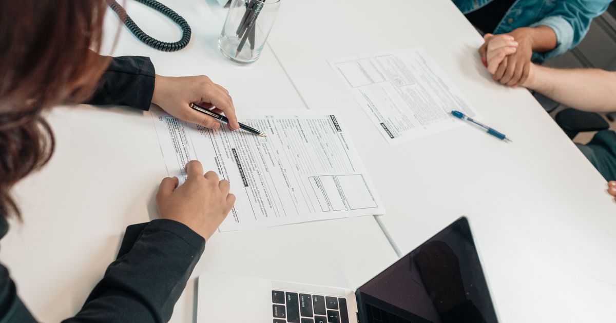 Going over an agreement line by line across a table, pen in hand