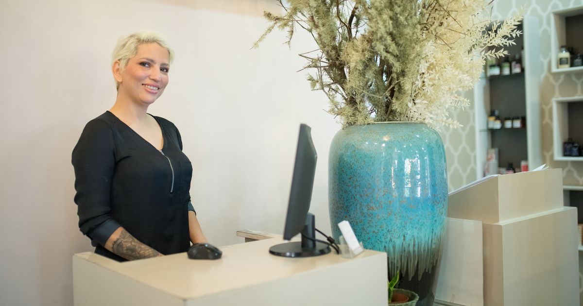 A receptionist at a salon's front desk, ready for the day's first client