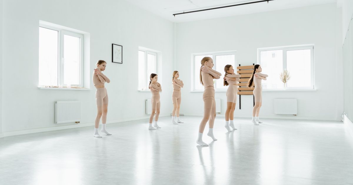 Young dancers warming up together in a bright, sunlit studio
