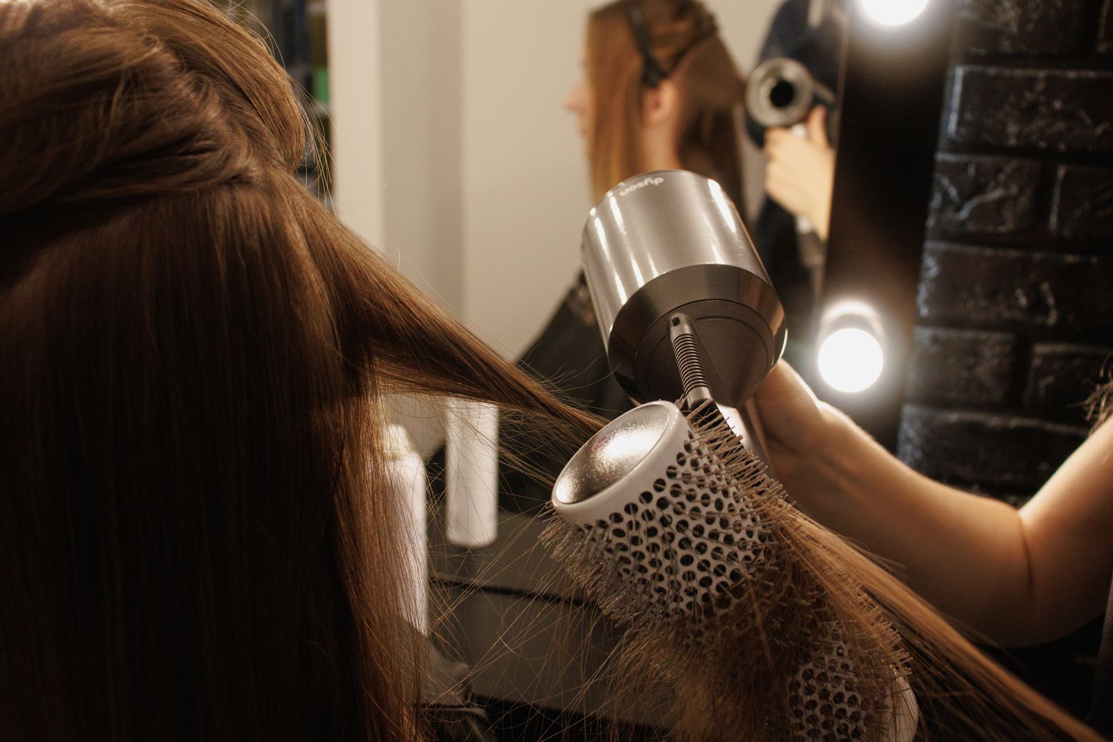 A stylist blow-drying long hair