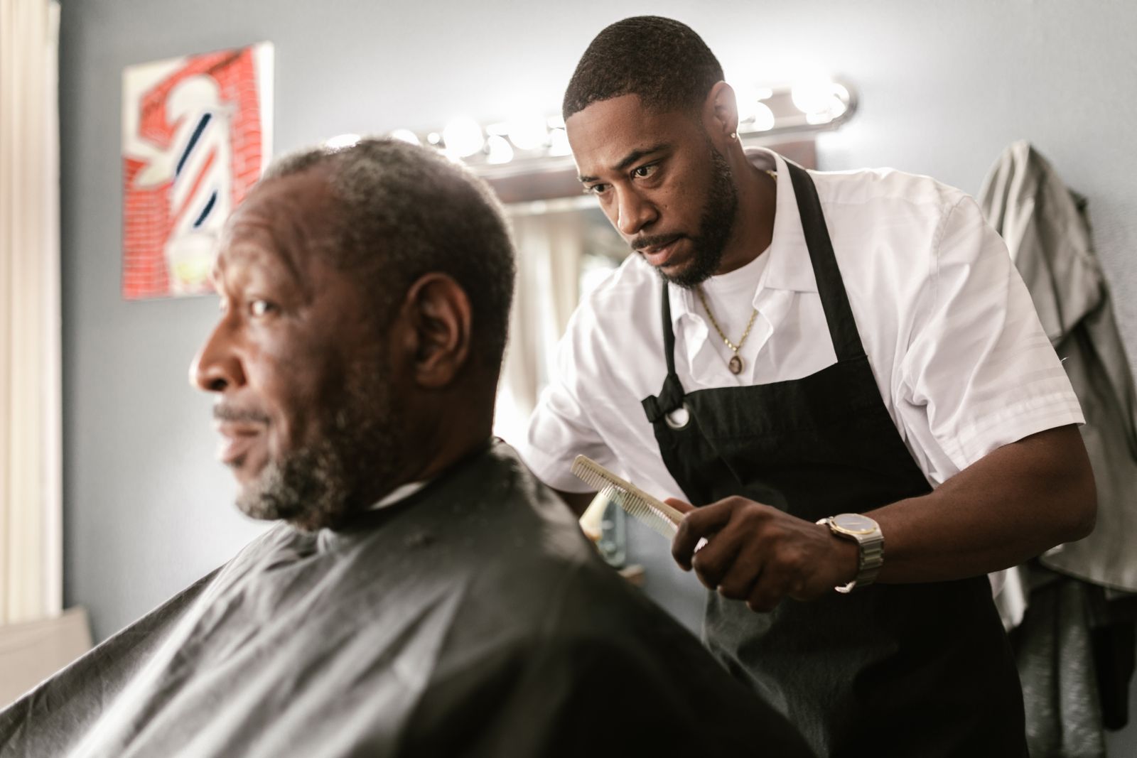 A barber combing a client's hair before a cut