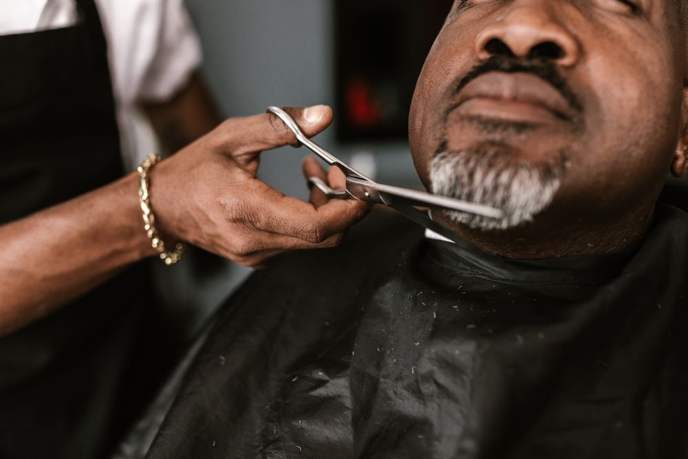 A grey beard trimmed with scissors