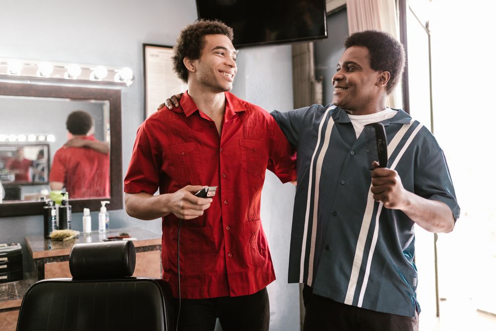 Two barbers sharing a laugh between clients