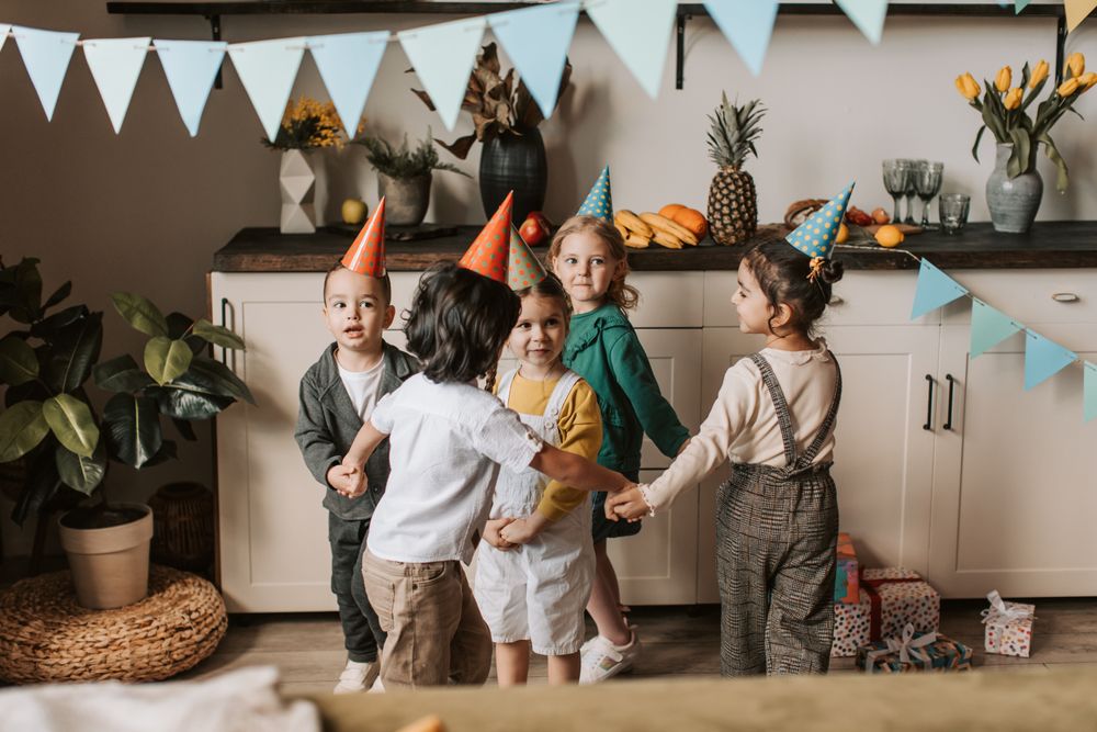 Kids in party hats dancing in a circle
