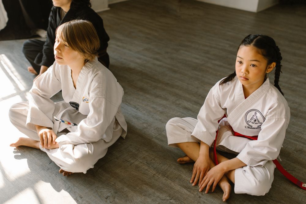 Two students waiting on the dojo floor