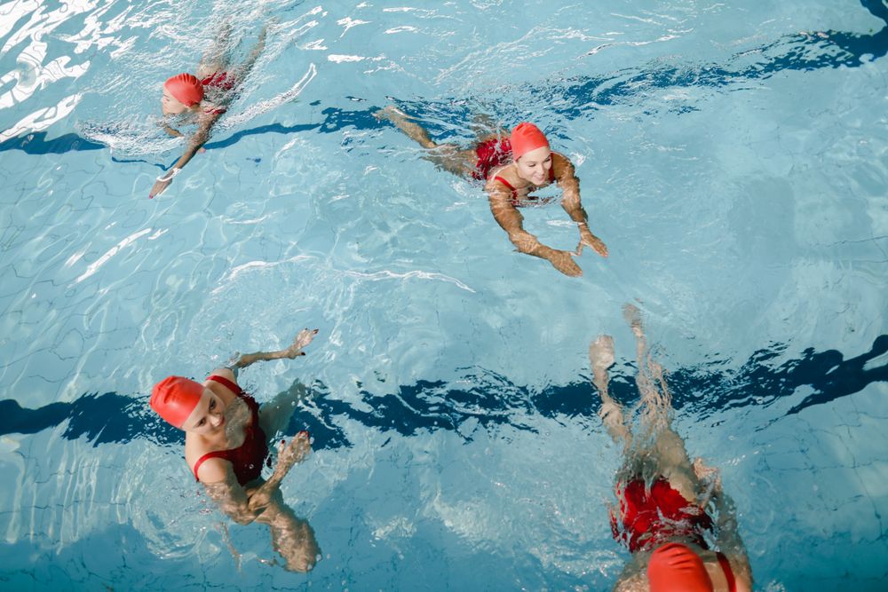 Swimmers in red caps doing lengths
