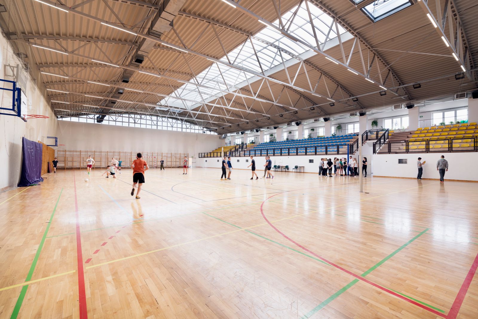 A busy community gym, with games on every court
