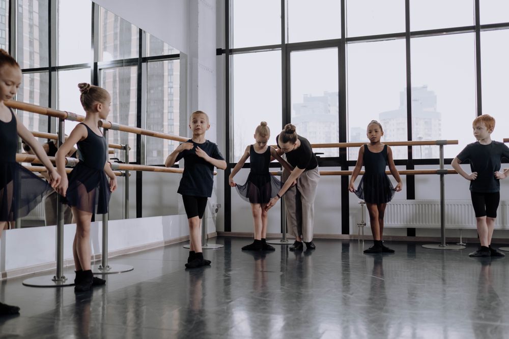 A teacher at the barre with her ballet class