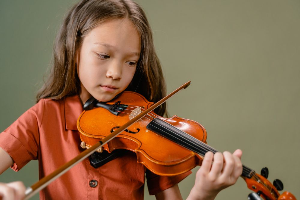 A young violinist concentrating on her bow