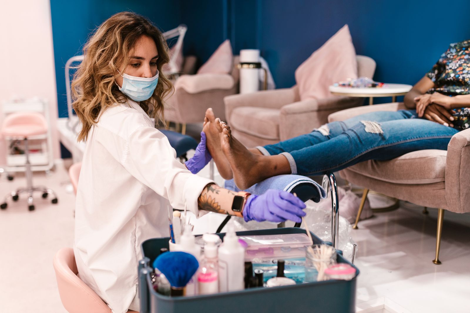 A pedicure in a bright nail studio, another client beside it
