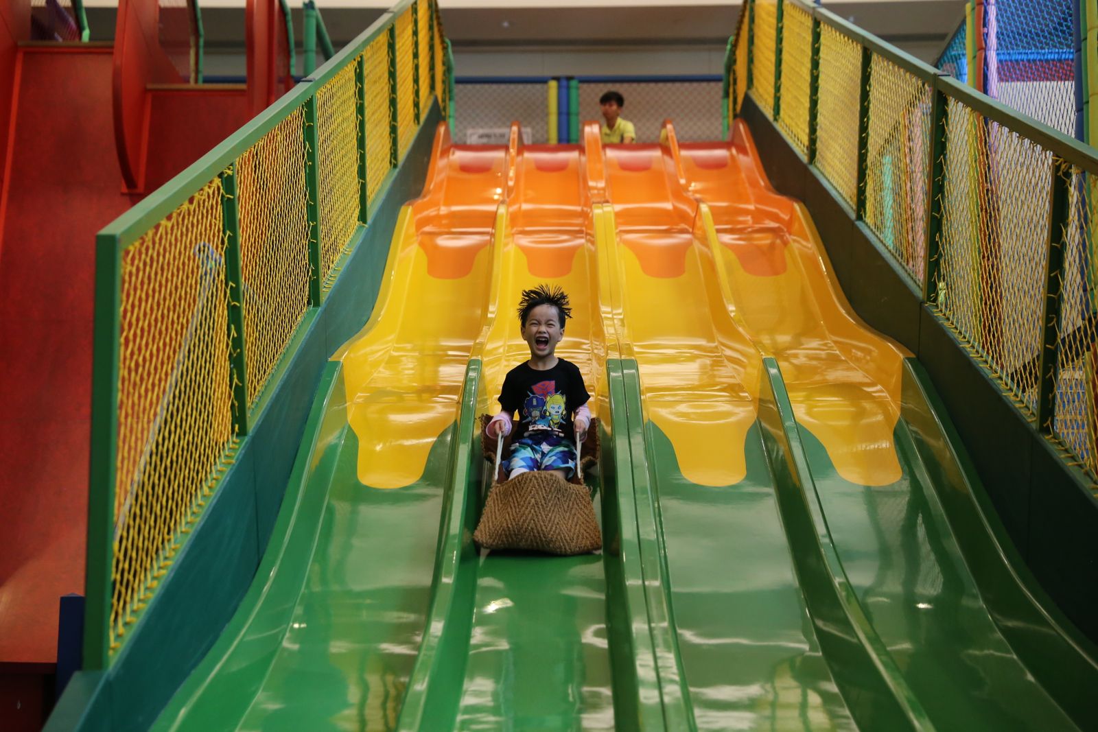 A child racing down an indoor slide