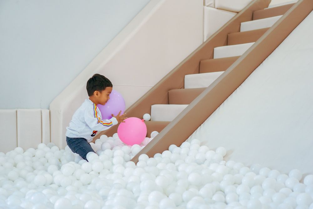 A boy playing in a ball pit