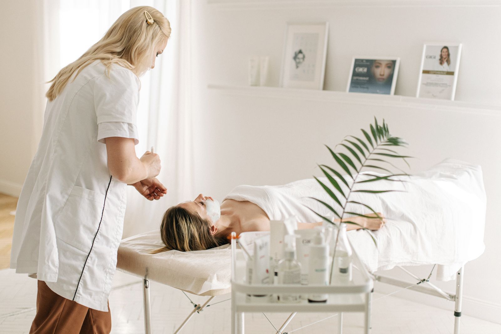 A therapist giving a facial in a bright treatment room