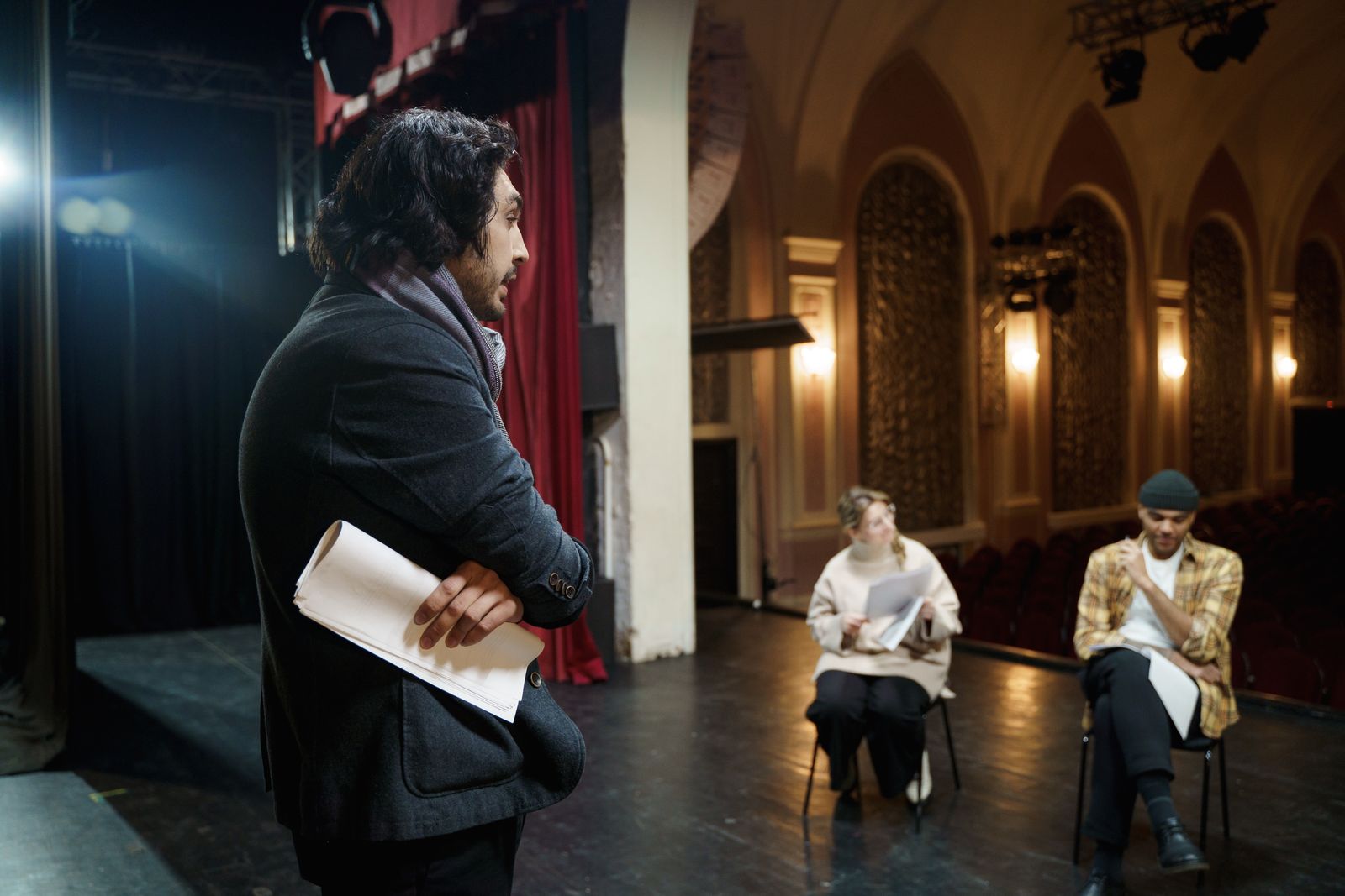 A director watching actors rehearse on stage