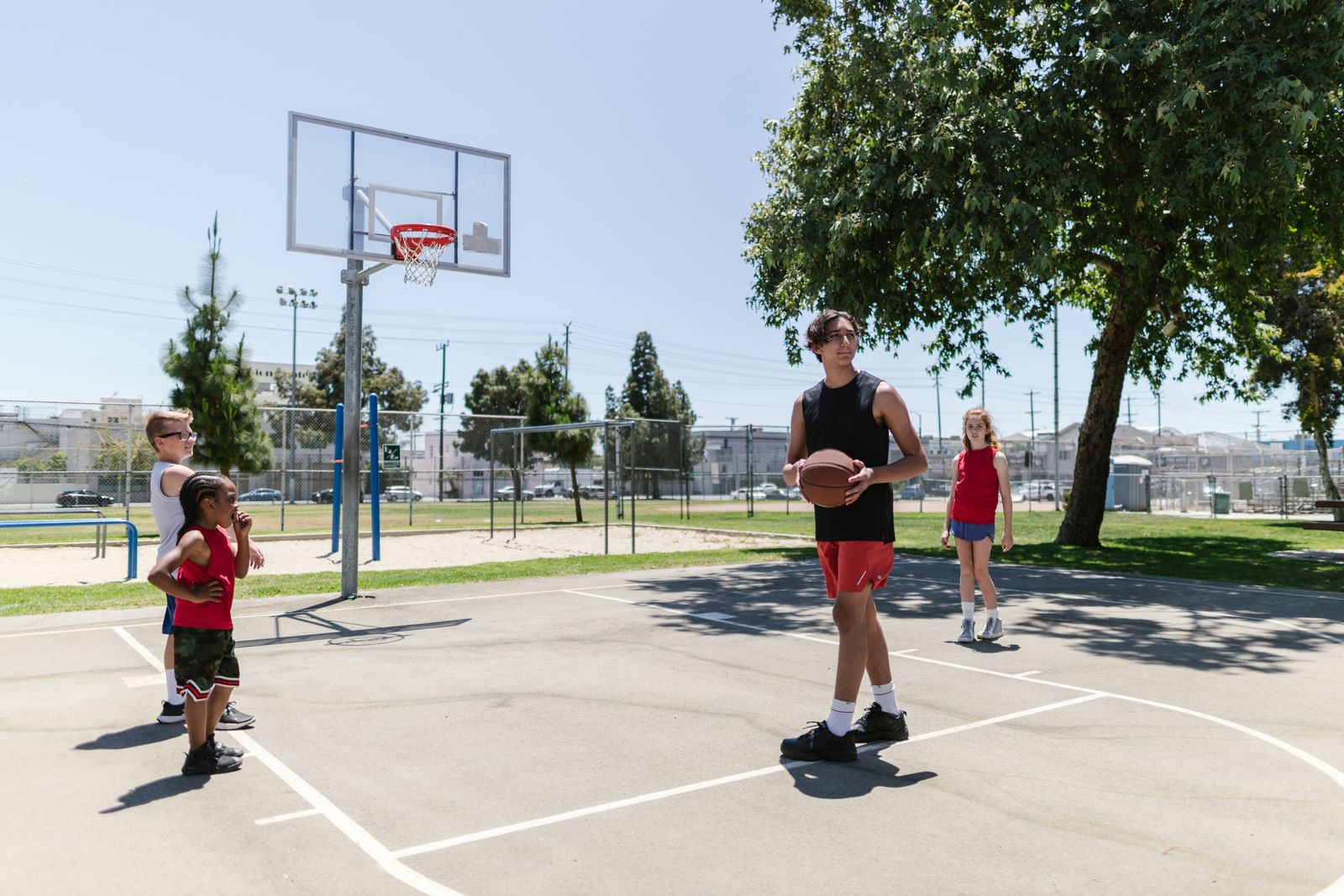 Kids practising basketball on an outdoor court