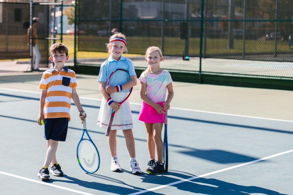 Kids with tennis racquets on the court